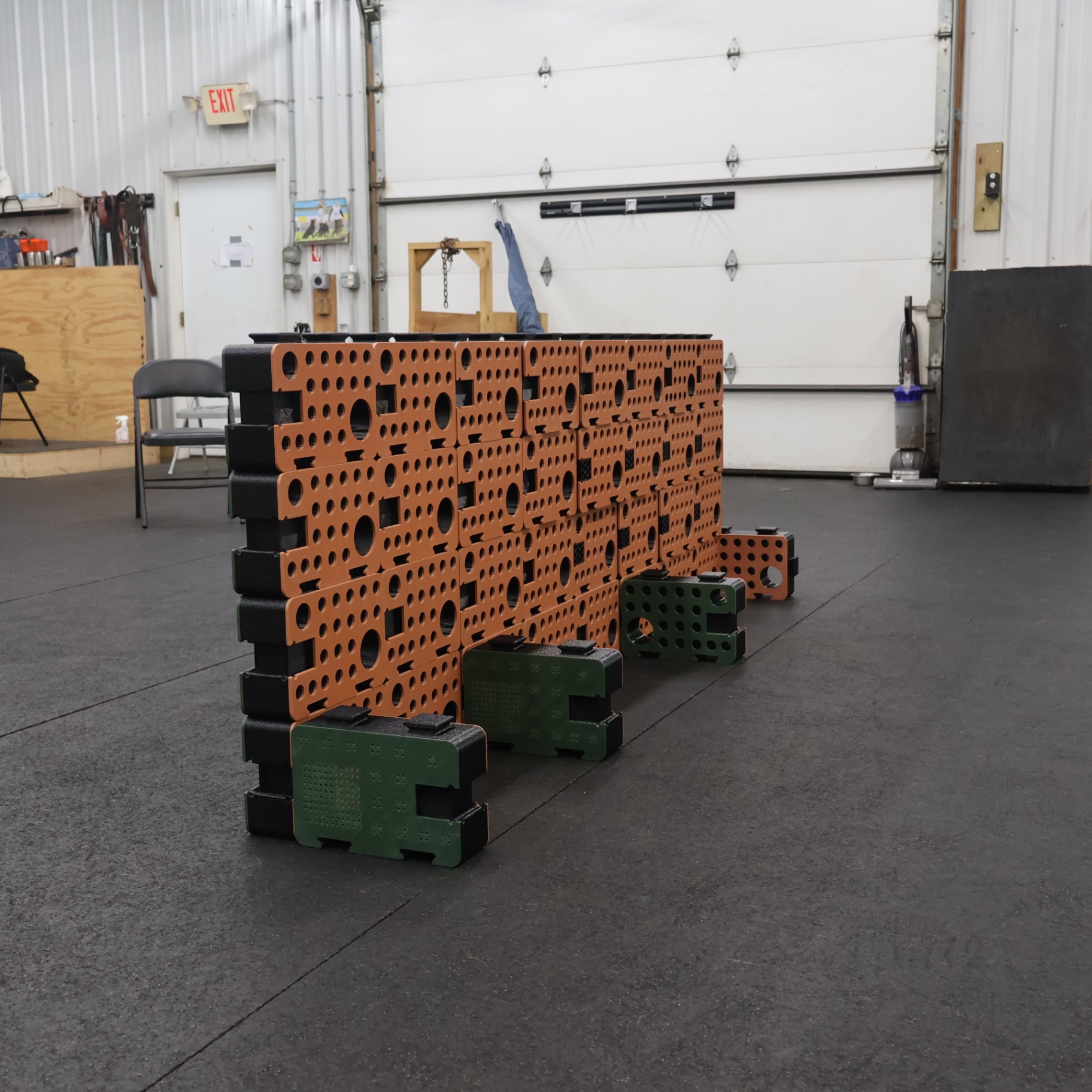 Side view of an orange D-Block wall with green and orange blocks placed at the base